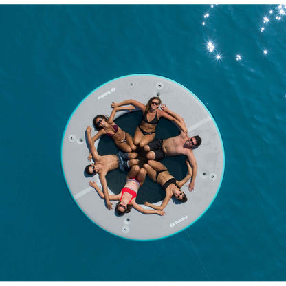 Group relaxing on Solstice Watersports 10' circular mesh dock in the water.