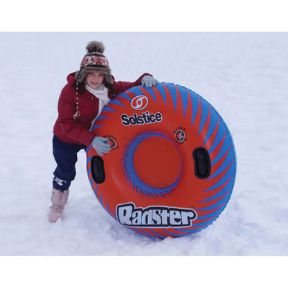 Child with Solstice Watersports 48" Radster Sport Tube in snow, featuring grab handles and vibrant design.