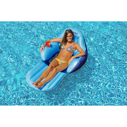 Woman relaxing on Solstice Convertible Solo Easy Chair in pool, with drink holder and footrest.