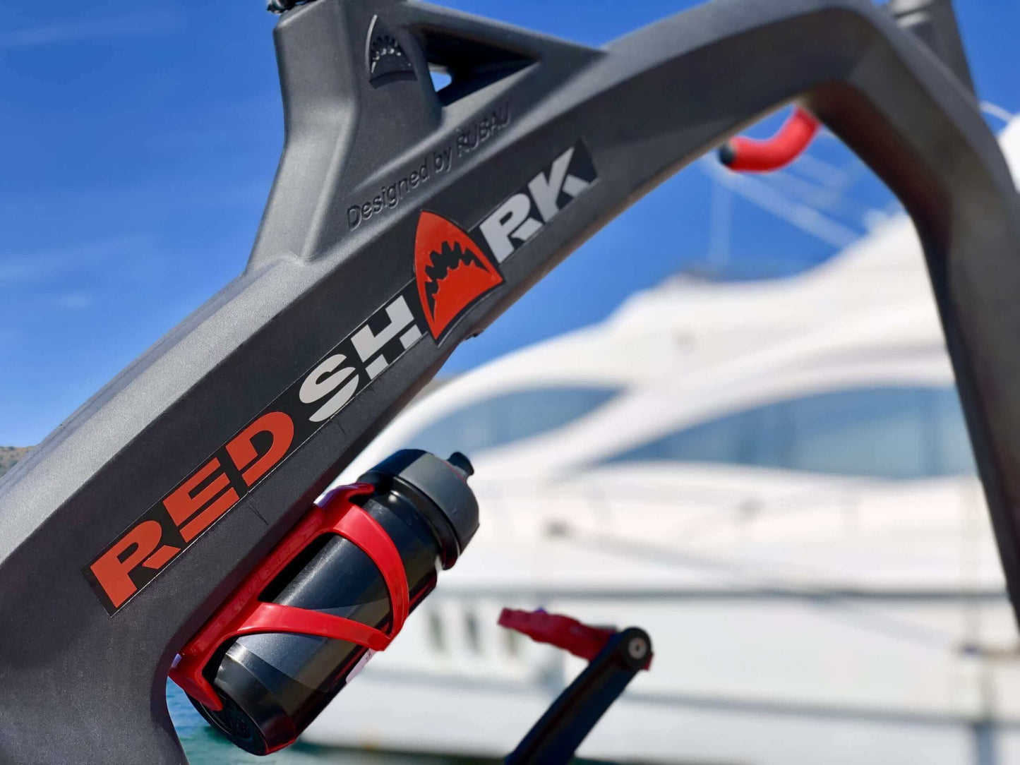 "Red Shark Fitness frame with water bottle holder against a yacht background, designed for aquatic workouts."